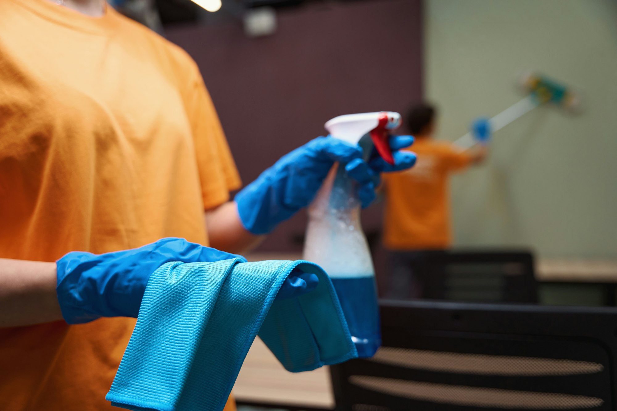 Dedicated janitor carrying disinfectant spray and wiping cloth