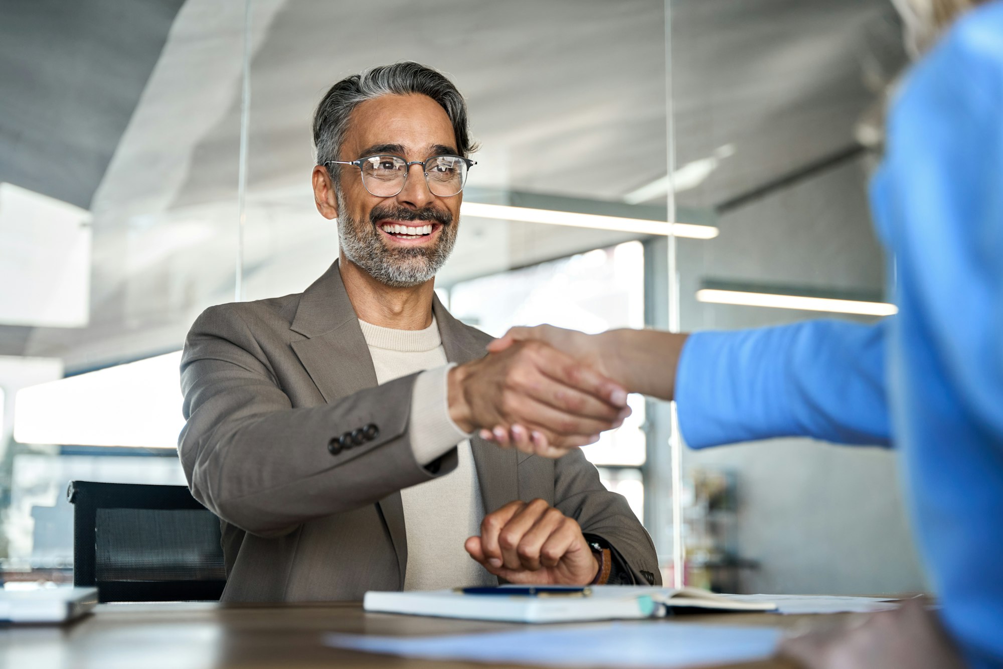 Happy middle aged business man hiring recruit at job interview. Handshake.