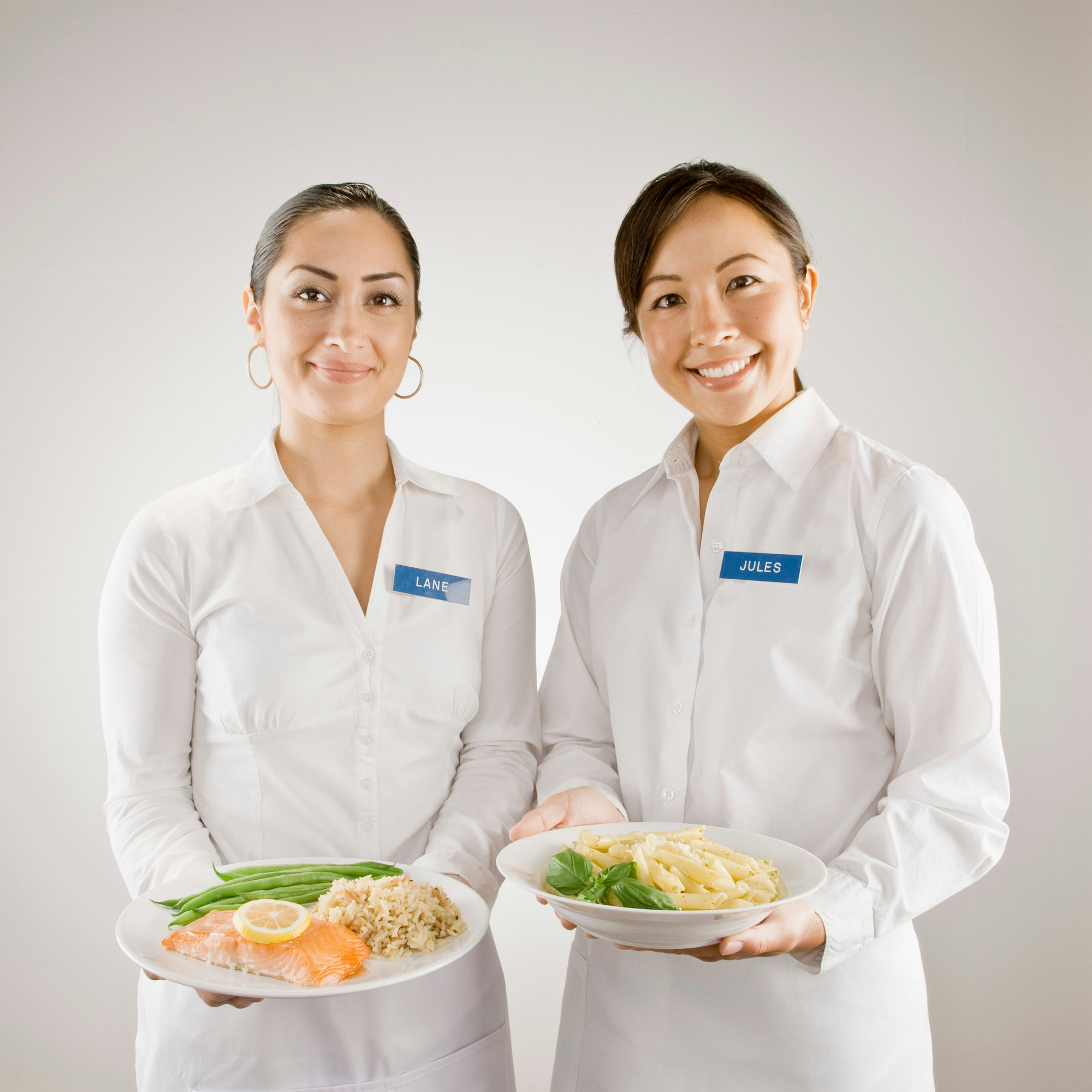 Servers in nametags with plates of food